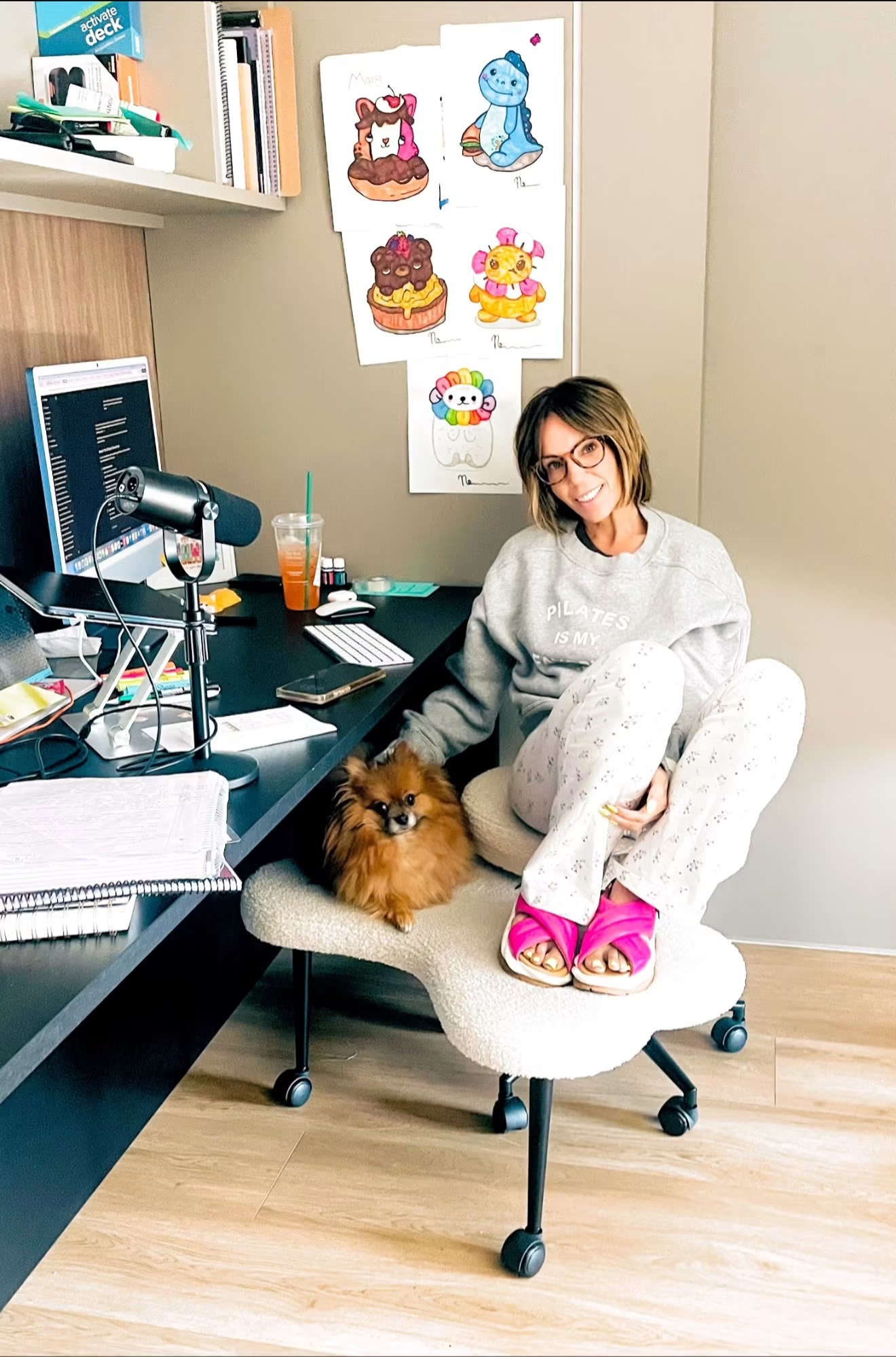 Martha Krejci working from her home desk with her dog beside her